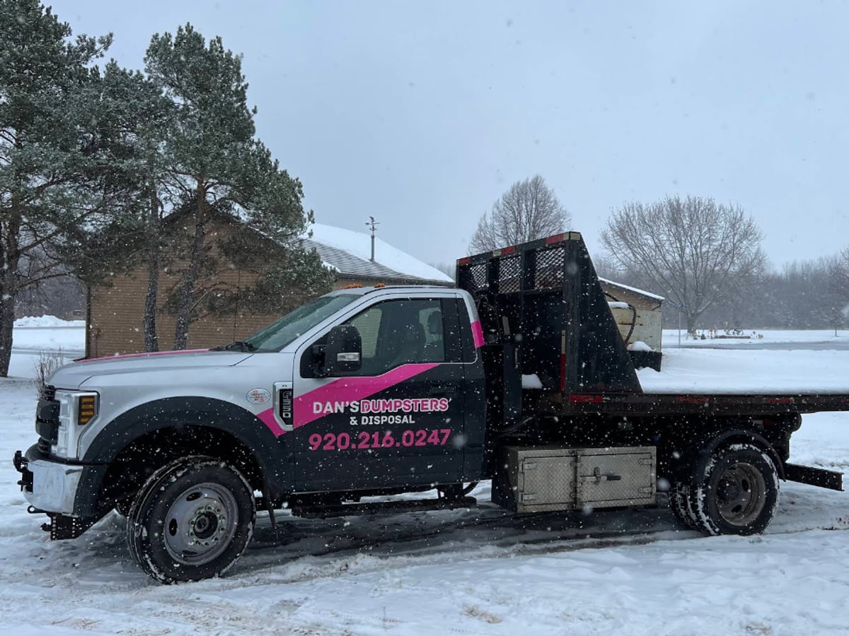 A Dan's Dumpsters truck out on a delivery in the snow during a Wisconsin winter